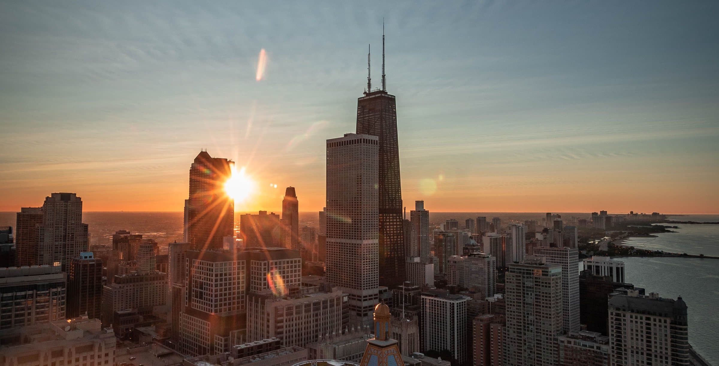 The Chicago skyline at sunset, with the John Hancock Center and Lake Michigan