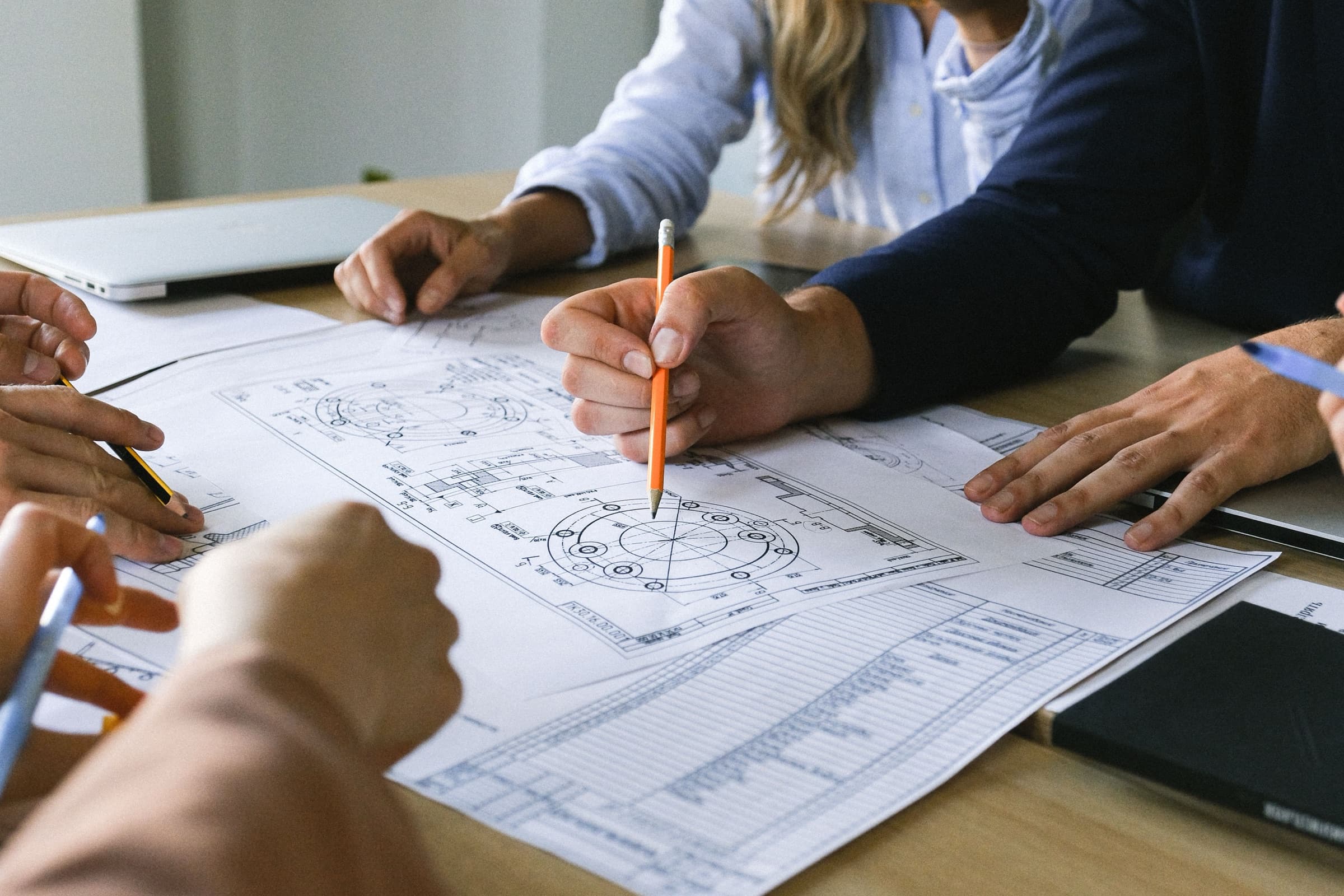 A team gathered around construction drawings, planning a project together