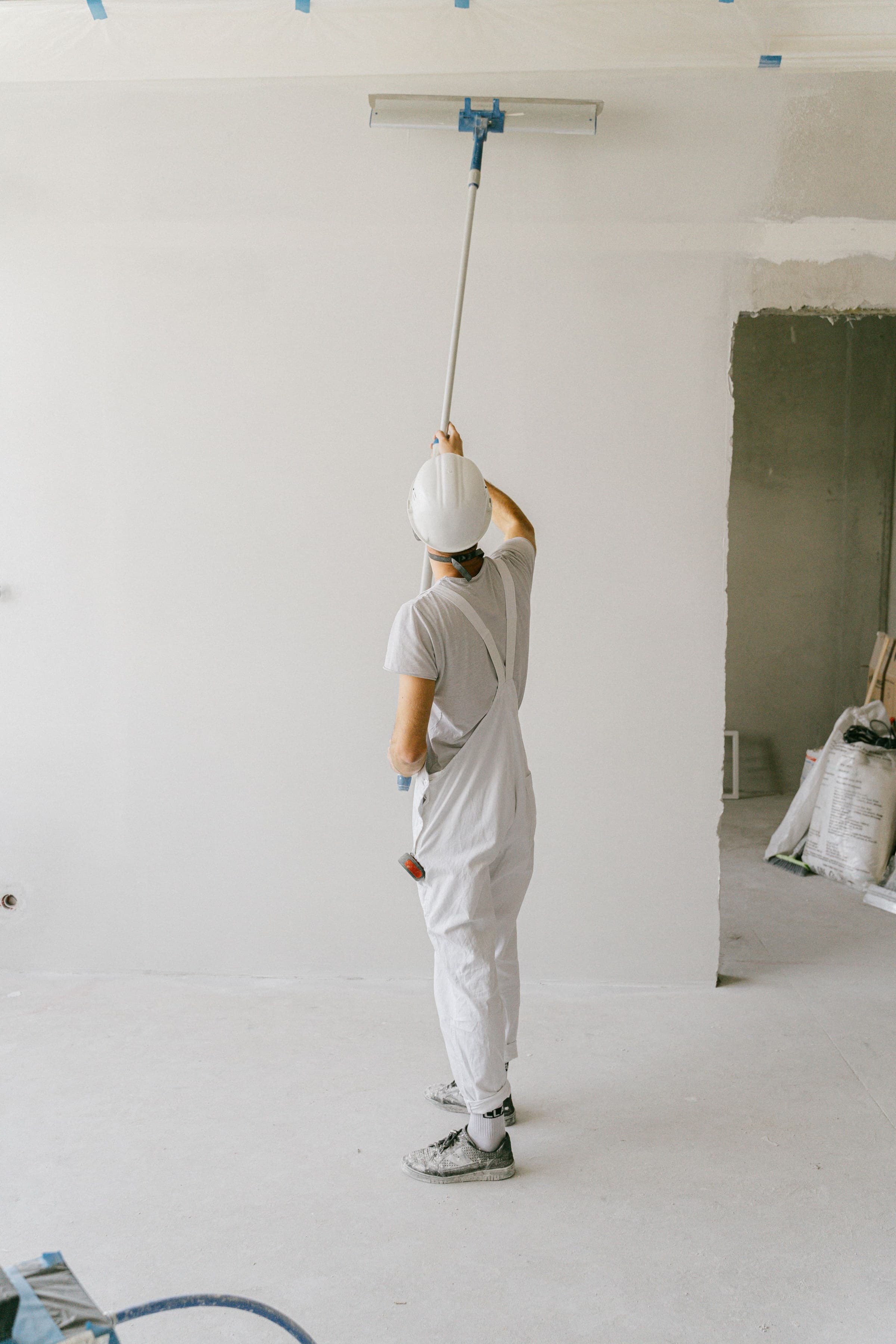 A contractor rolling paint onto a ceiling during a commercial renovation