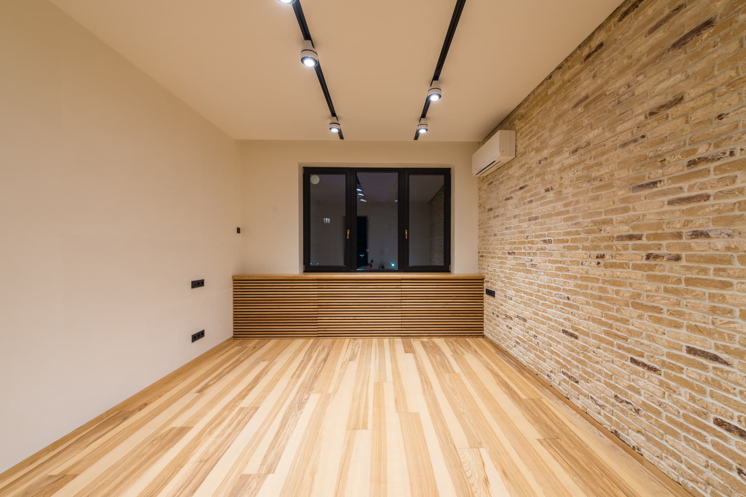 A finished commercial interior with an exposed brick accent wall and wood slat detailing