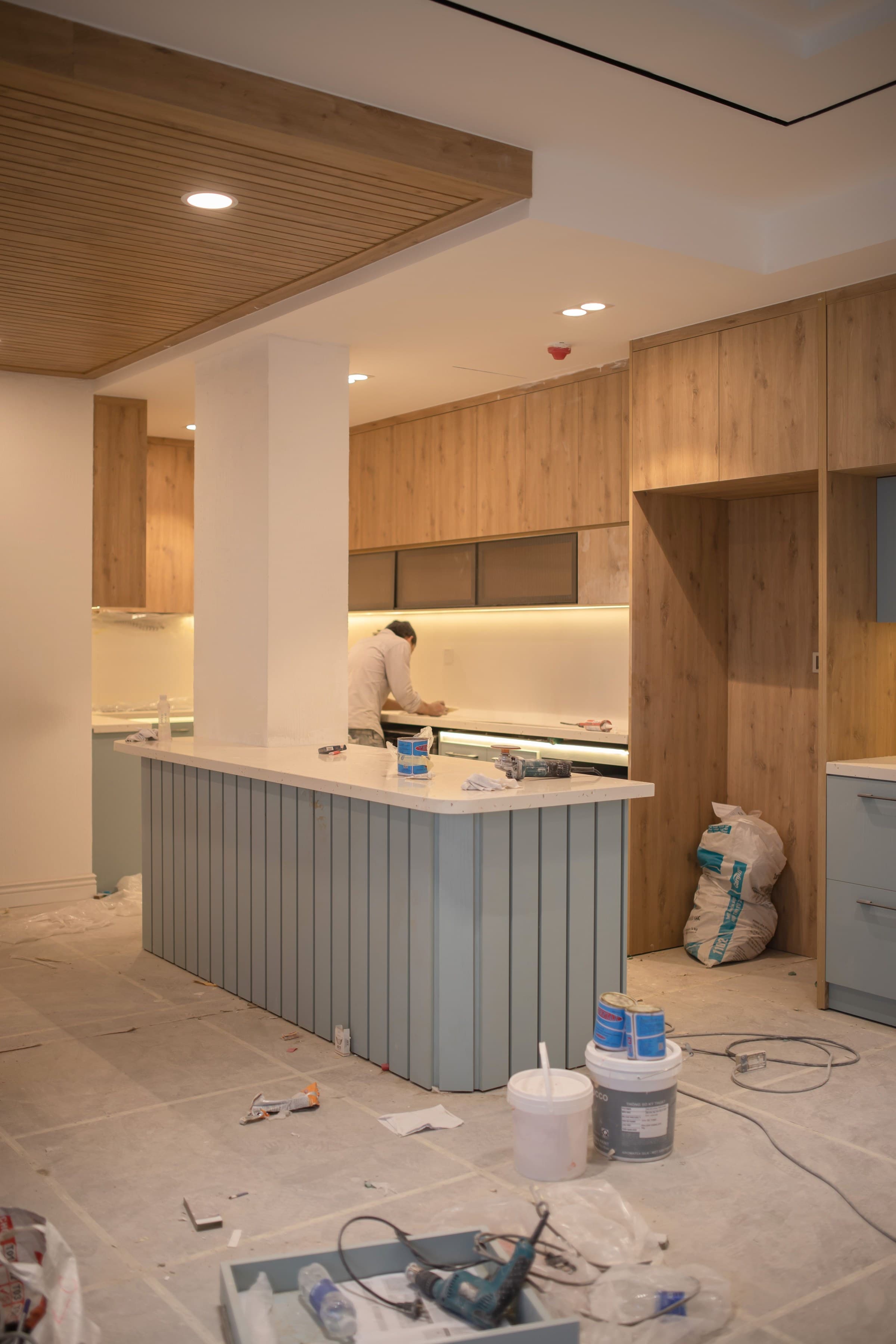 A commercial kitchen build-out in progress, with cabinetry being installed