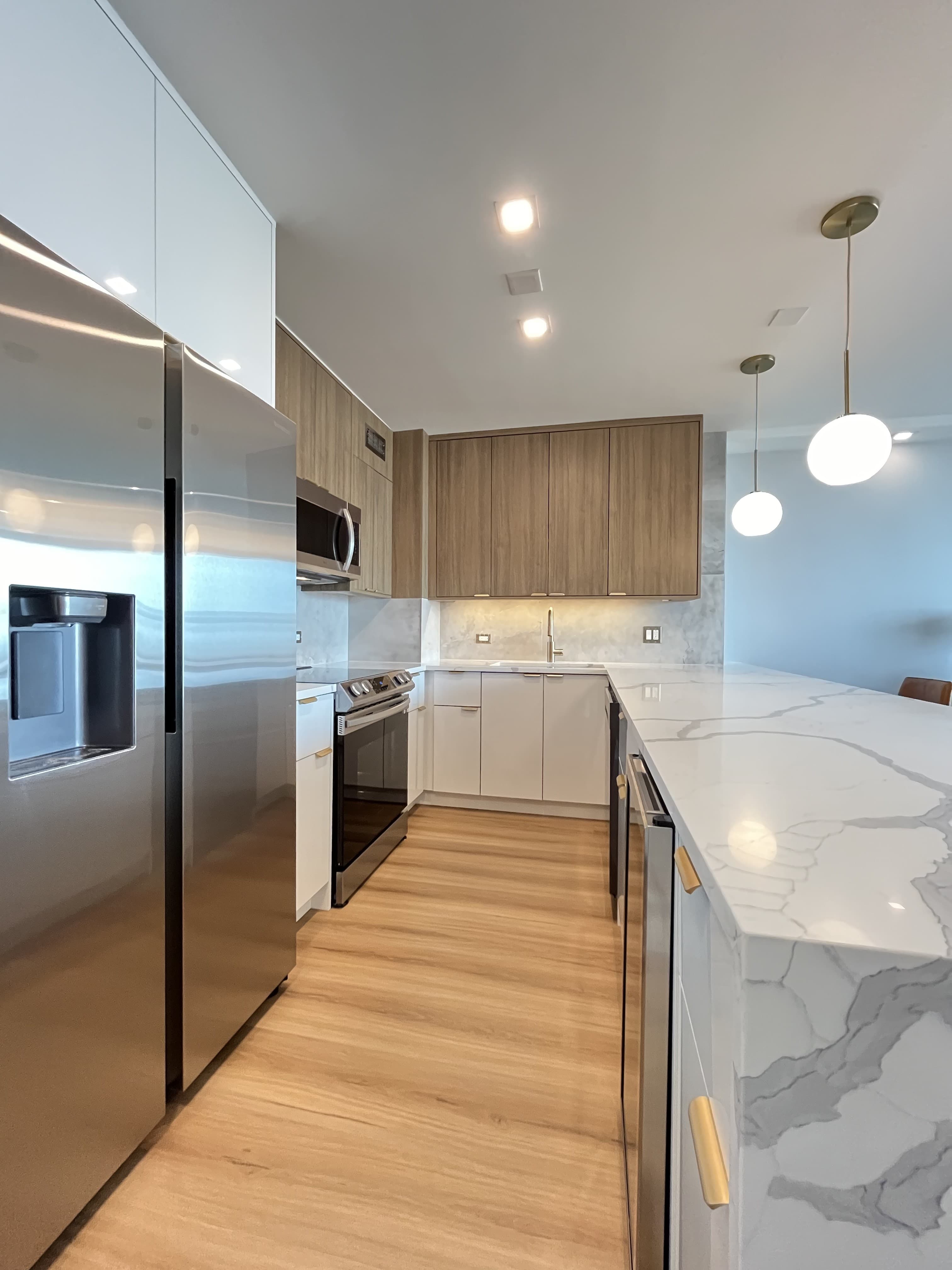 A full galley view of the renovated kitchen toward the waterfall island