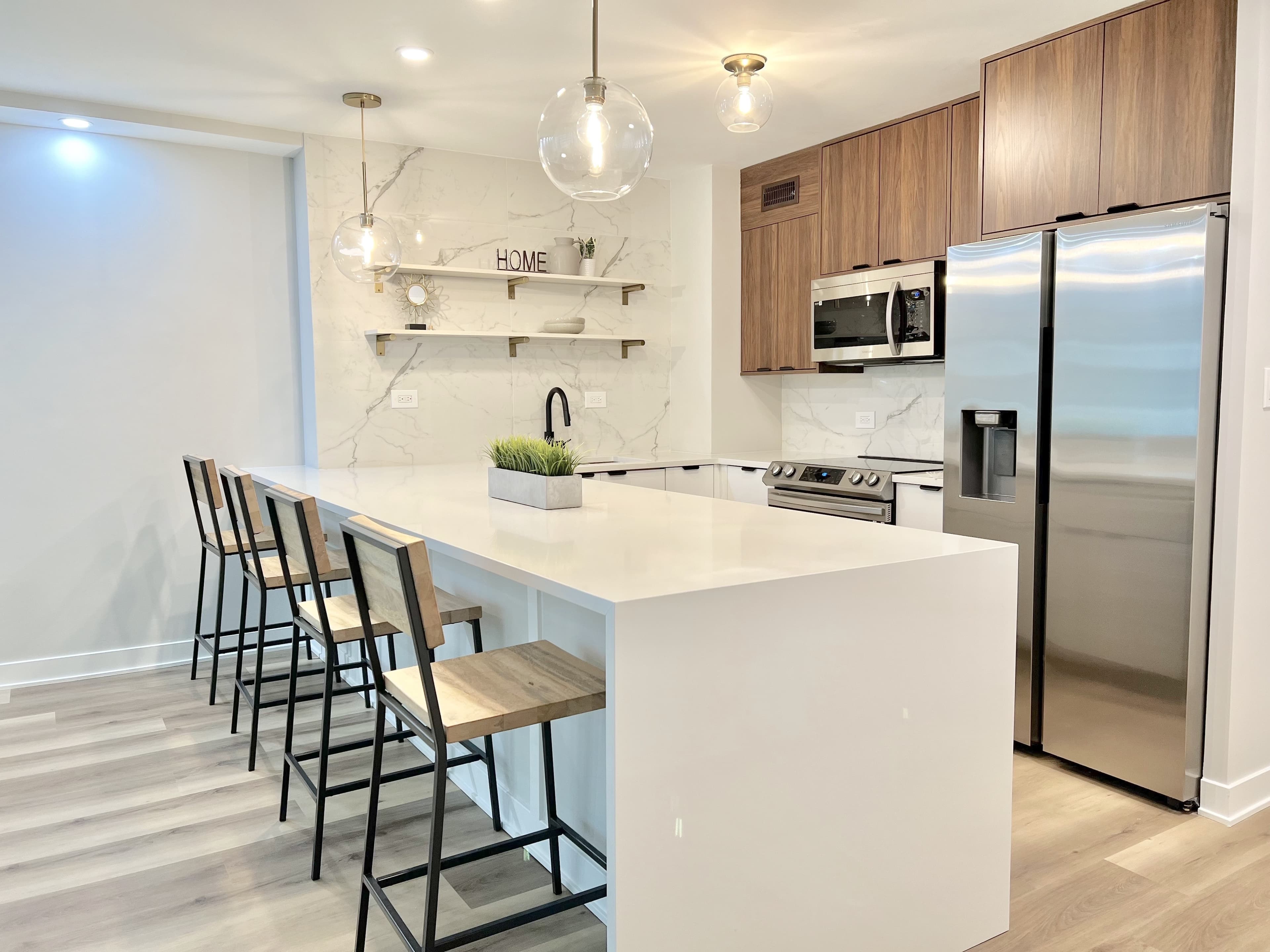 A renovated kitchen with a waterfall-edge island and walnut cabinetry