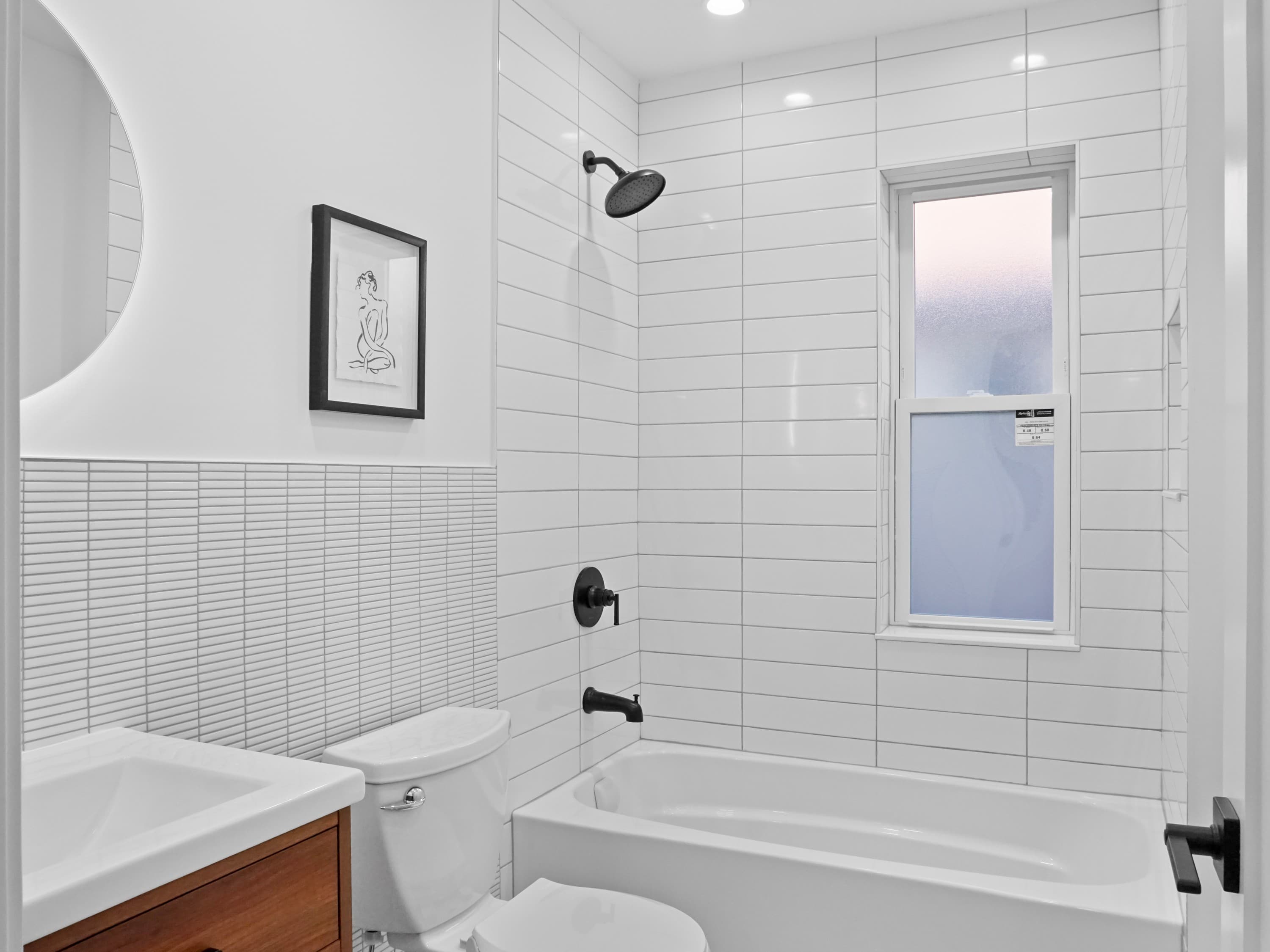 A modern bathroom with white subway tile and black fixtures