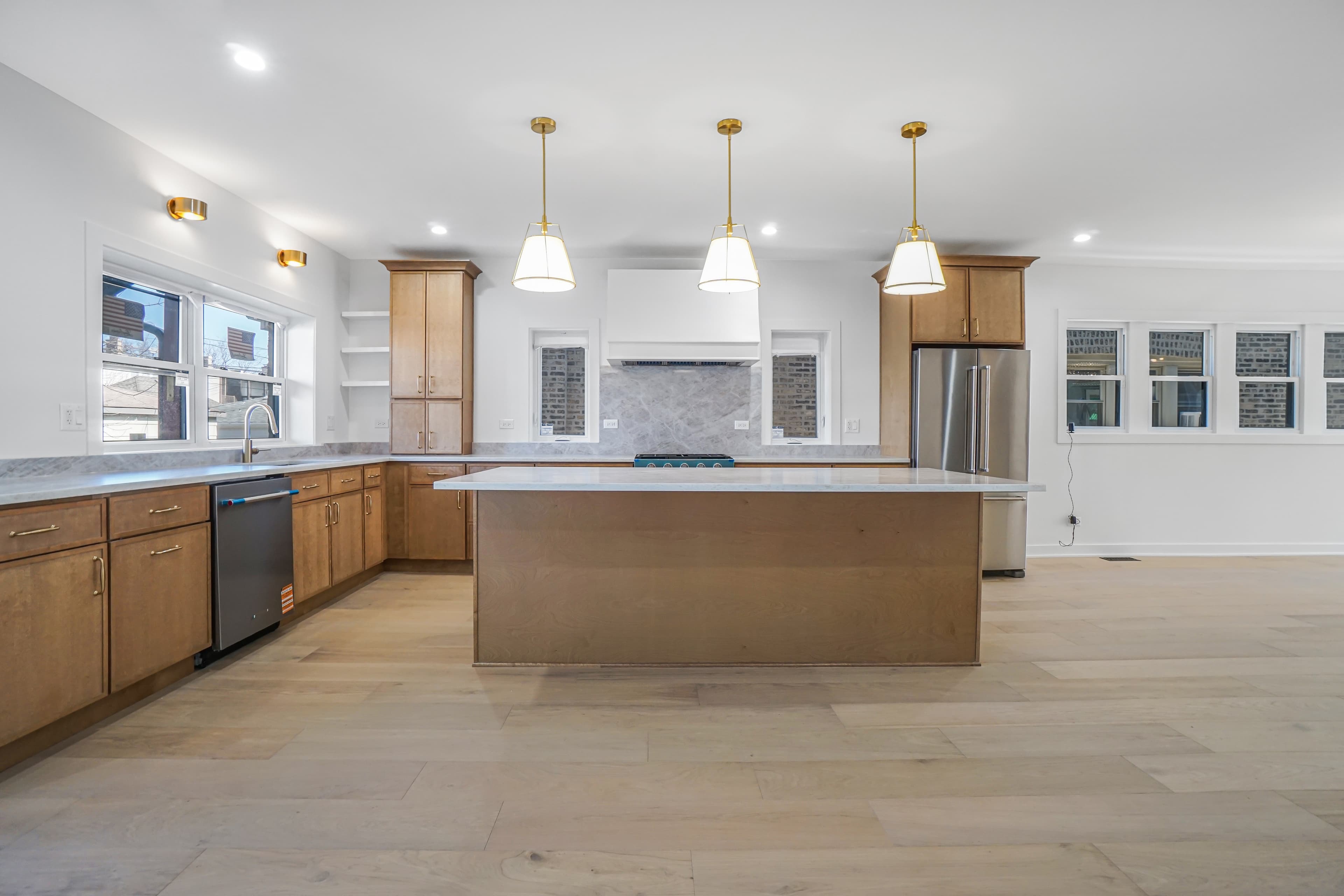A large renovated kitchen with an oversized island and pendant lighting