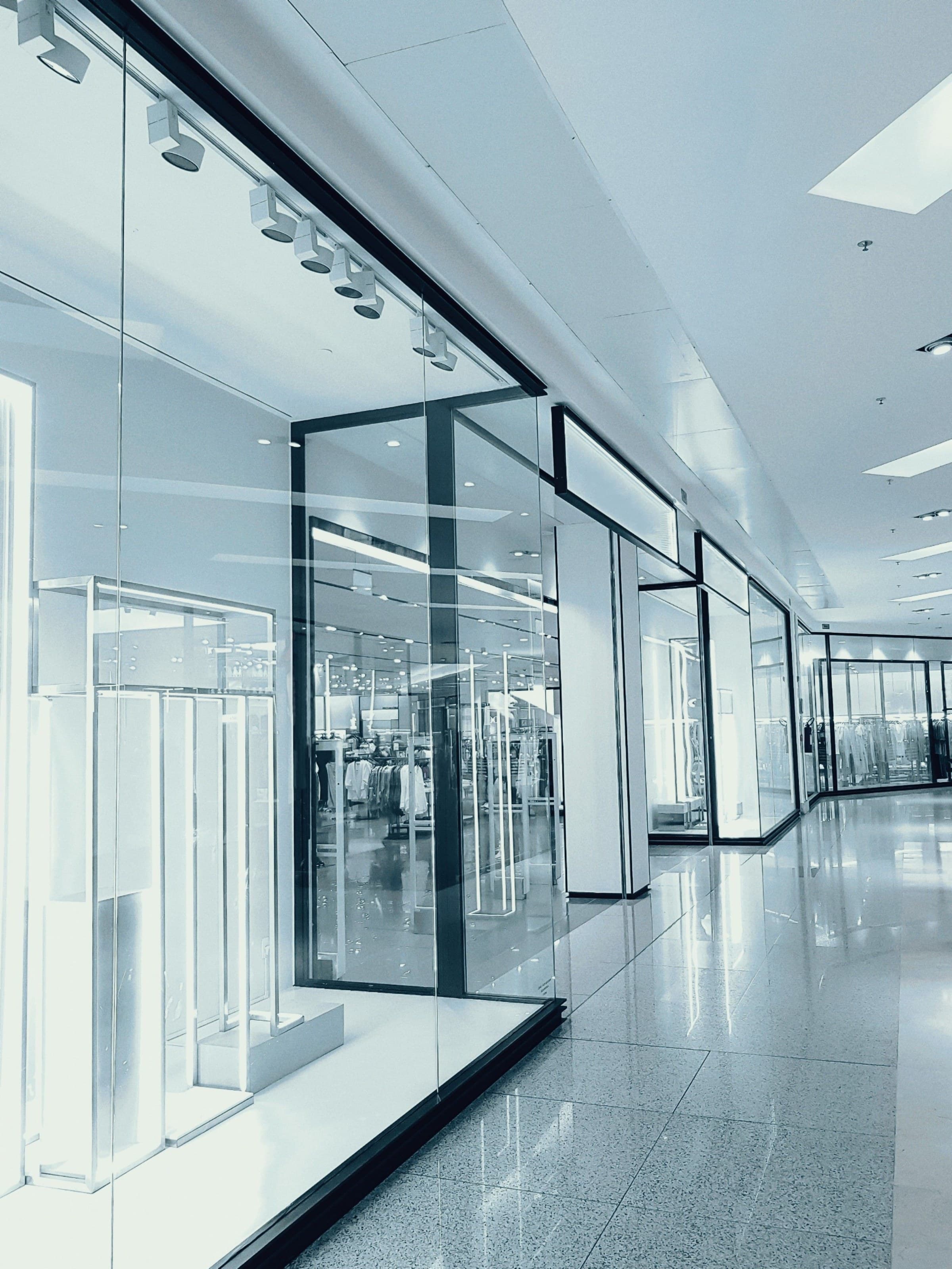 A commercial corridor lined with storefront glass walls
